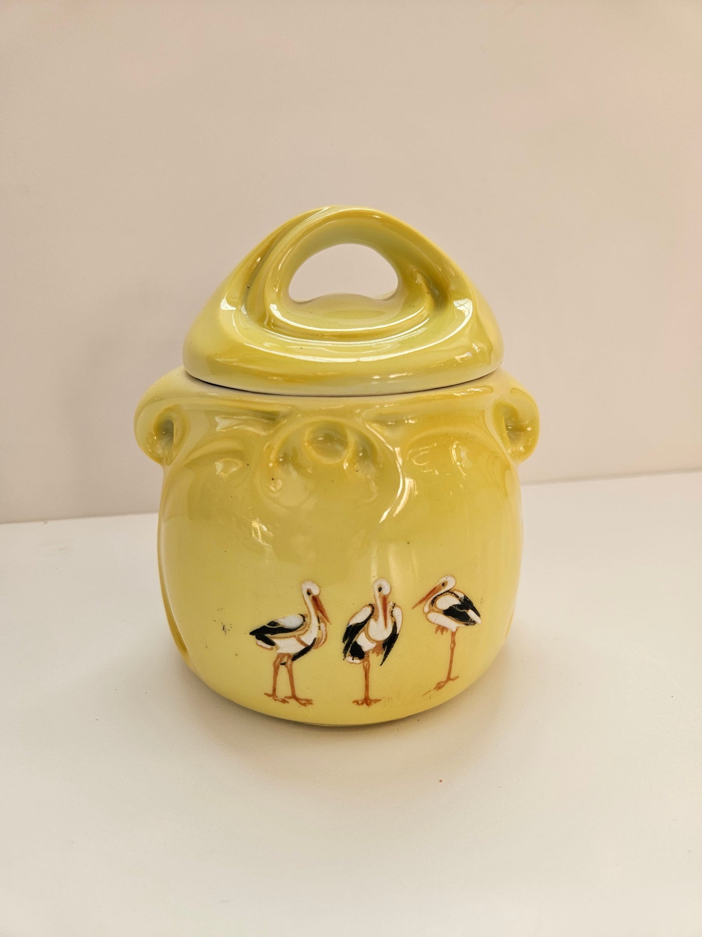 Yellow ceramic mug with bird design on a white background