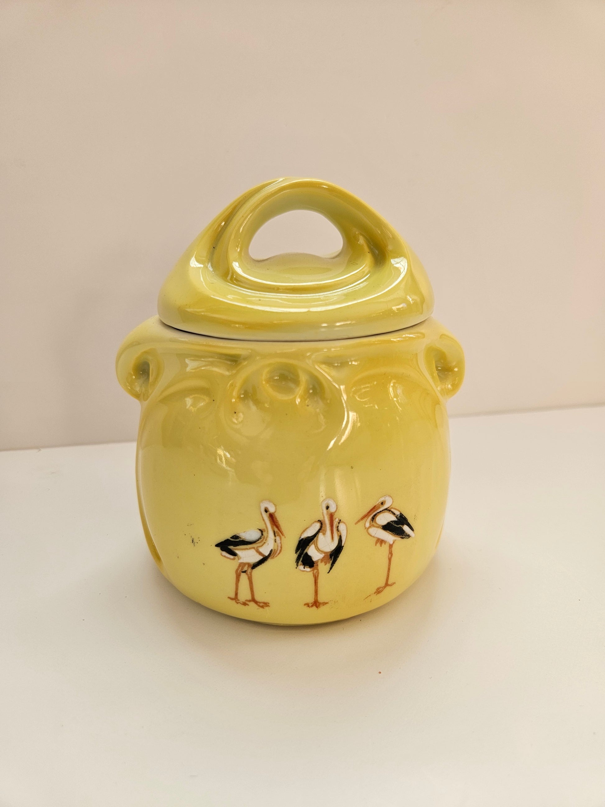 Yellow ceramic mug with bird design on a white background
