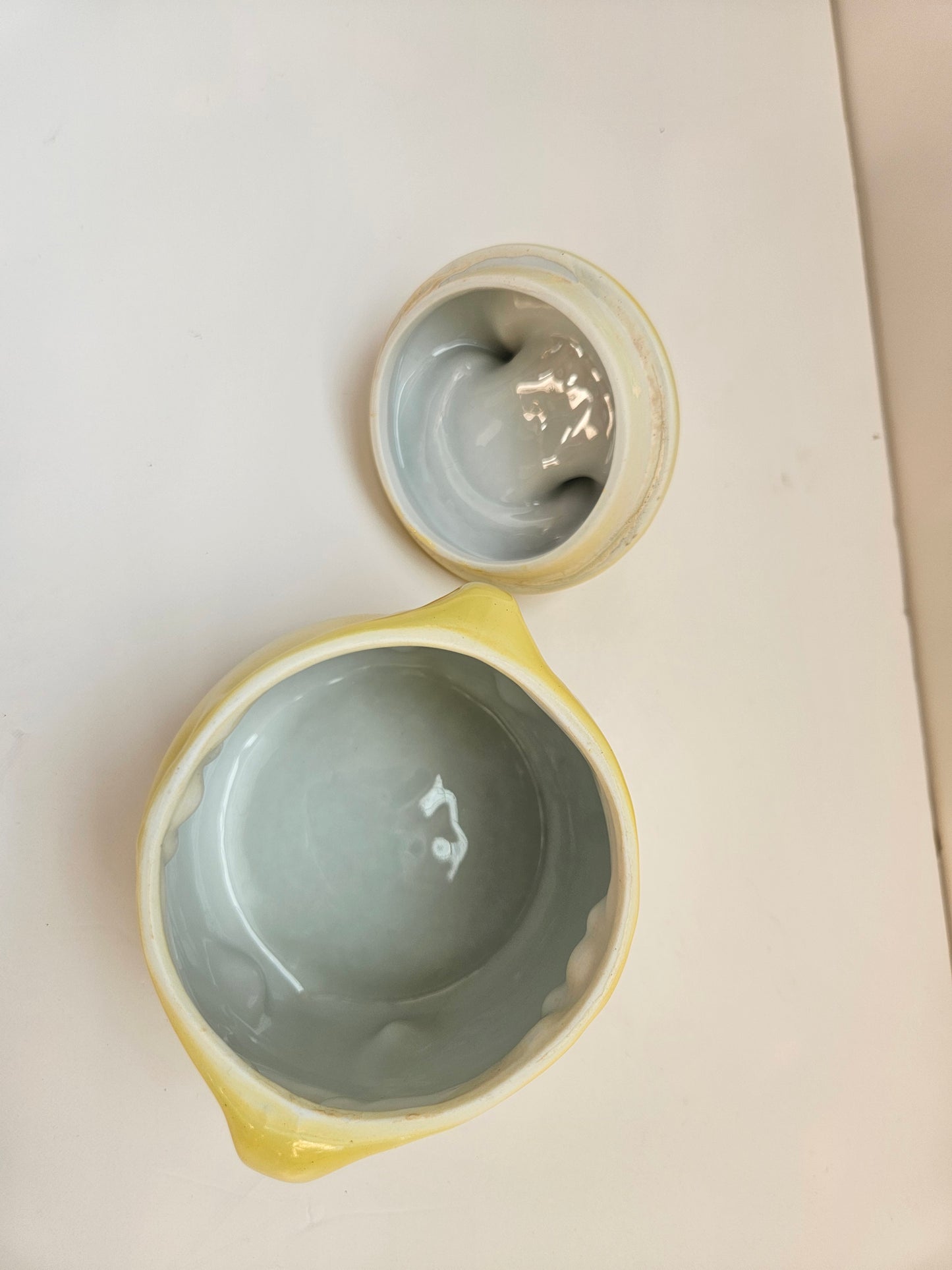 Two ceramic bowls with a light interior on a white surface
